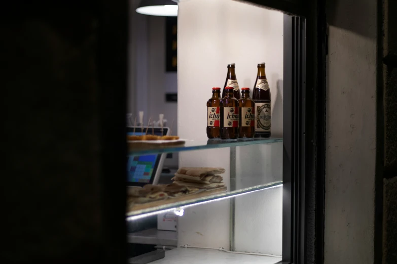 two different beers are displayed behind a glass shelf