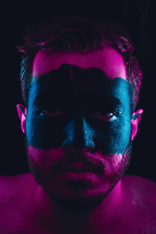 a man with his face painted in blue and pink