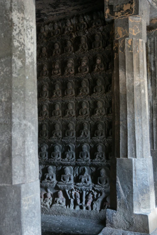 a group of stone faces decorate the side of a building