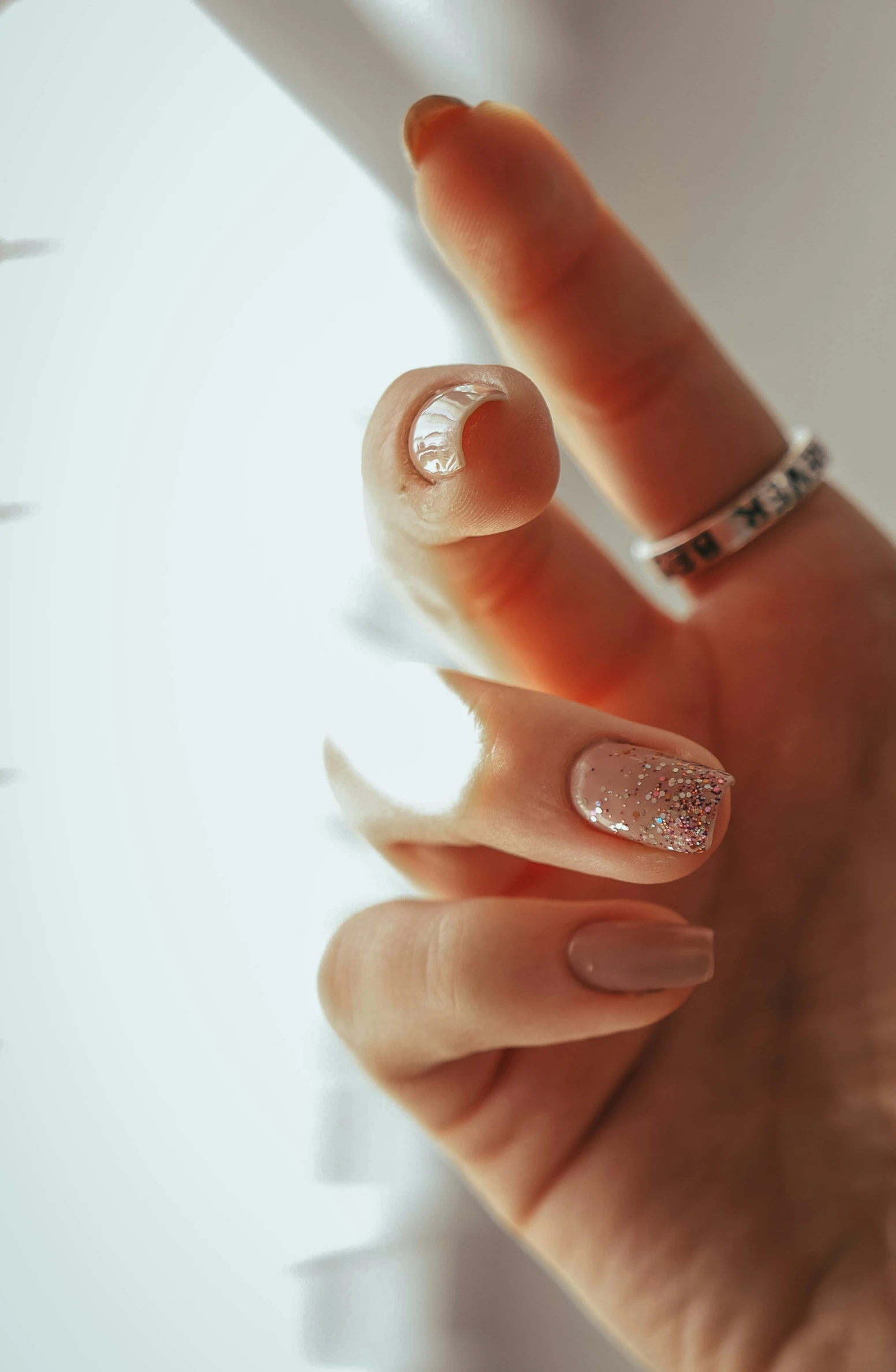 a womans hand with nail art in white and gold