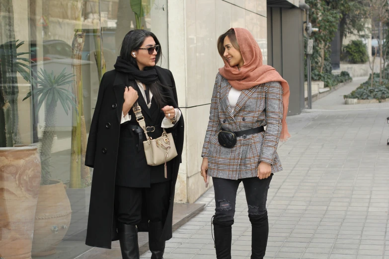 two women on sidewalk looking at one another