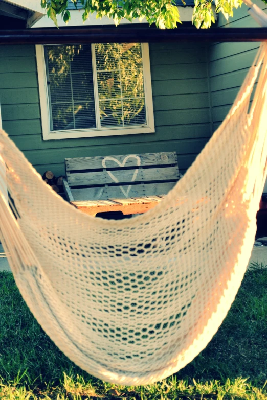 the hammock is hanging outside on the lawn
