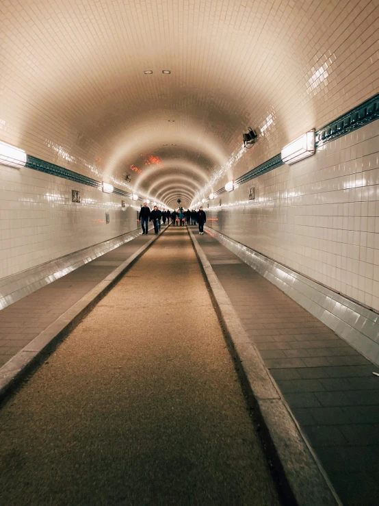 some people stand in an escalator that is underground