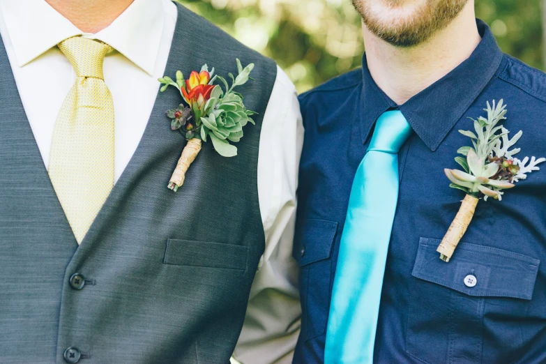 two men wearing vests and ties with a boutonniere on them