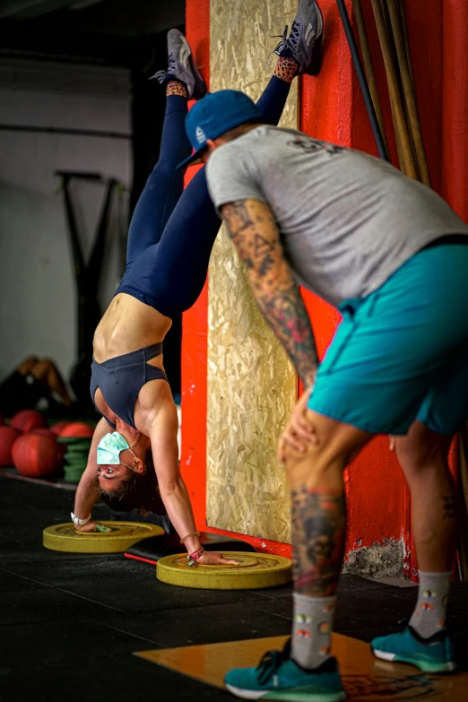 two people in yoga gear standing on their feet doing a handstand pose