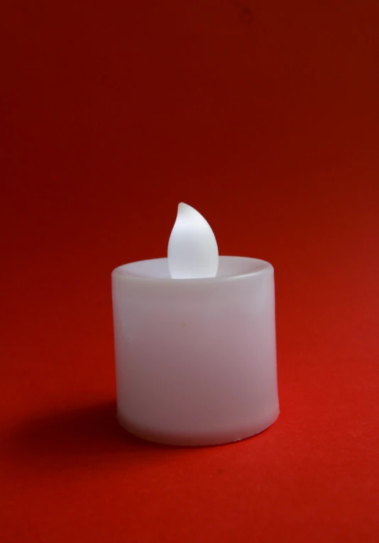 the candle is white and has an object on top of it