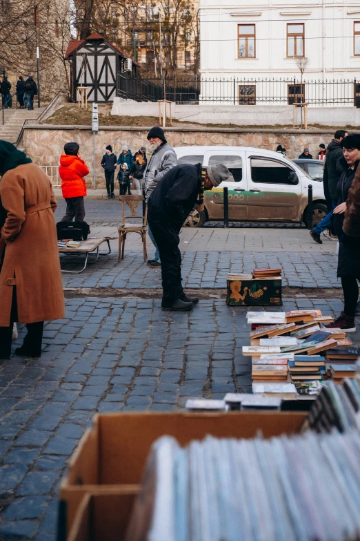 people buying books out on the sidewalk in the winter