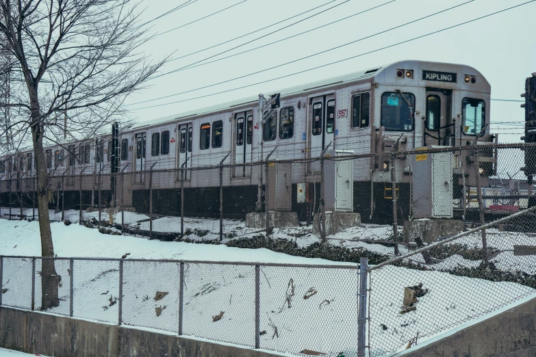 a passenger train in the snow, on the tracks