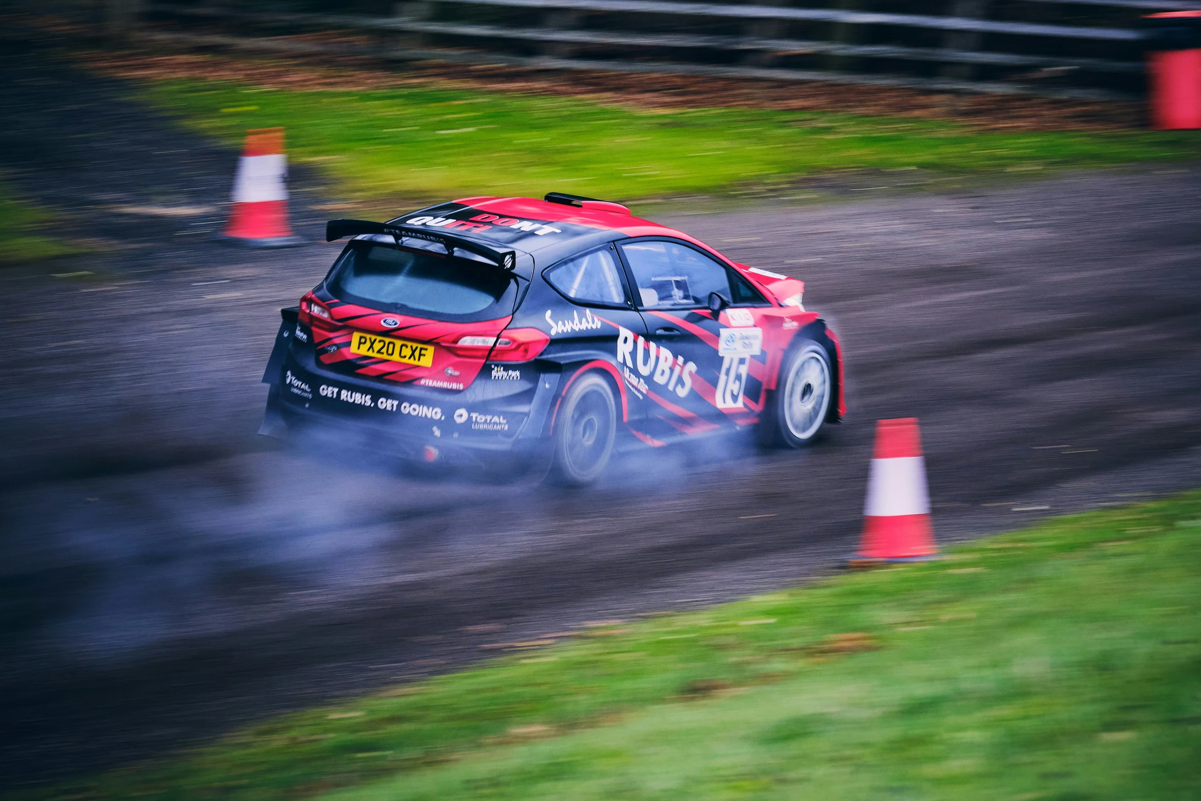 a car with red paint is driving down a track