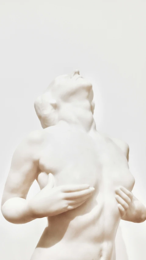 the statue is covered with white plaster and features a beautiful figure in his arms