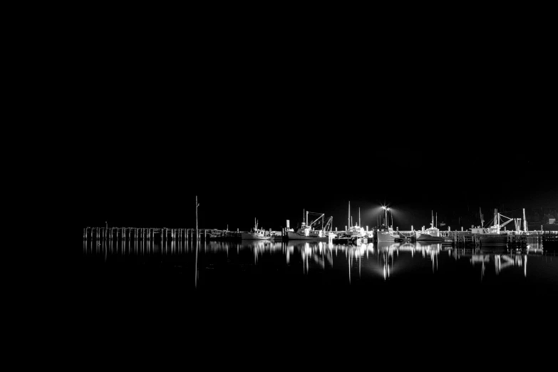 the lights of boats are reflected in the water