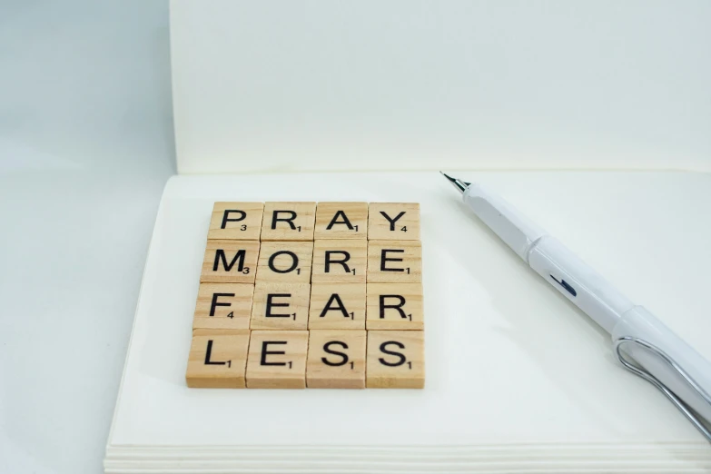 crossword tiles spelling pray, be less and help from a sharpie