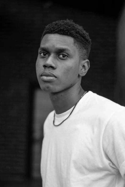 a young man poses with his hand in his pocket