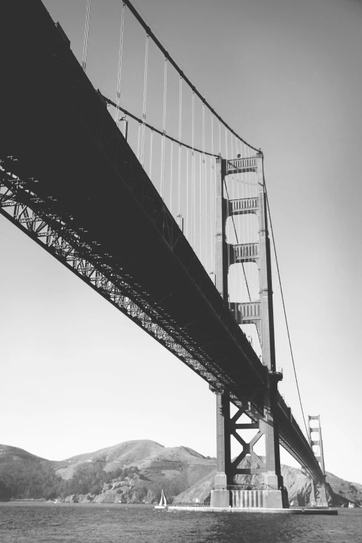 the underside of a bridge looking down from a boat on the water