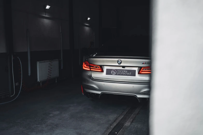 the front of a silver car is parked in the garage