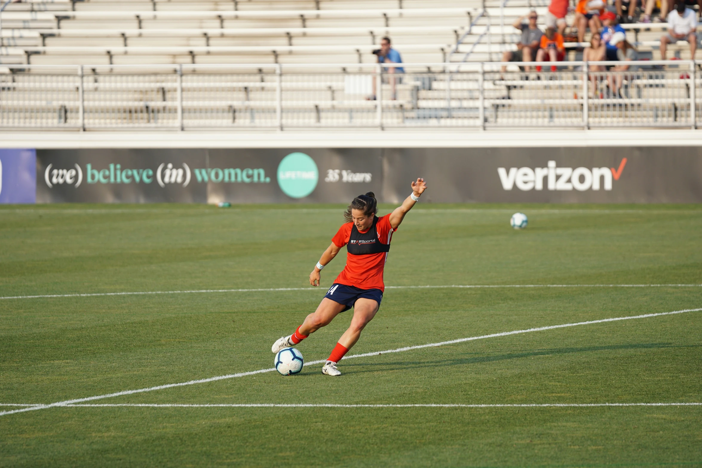 women are playing soccer on a green field