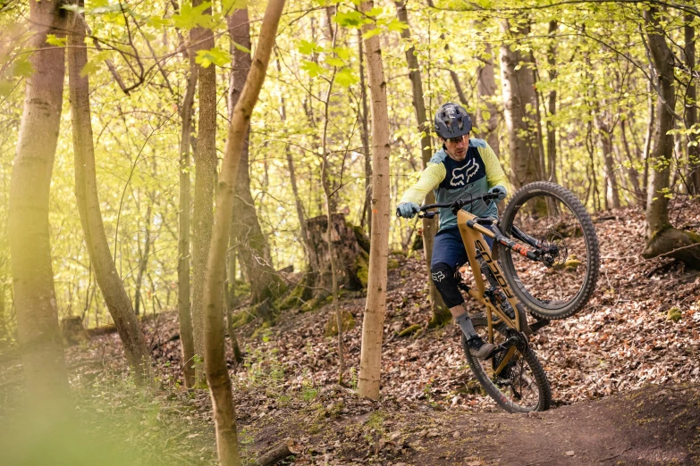 a man riding a bike down a trail next to trees