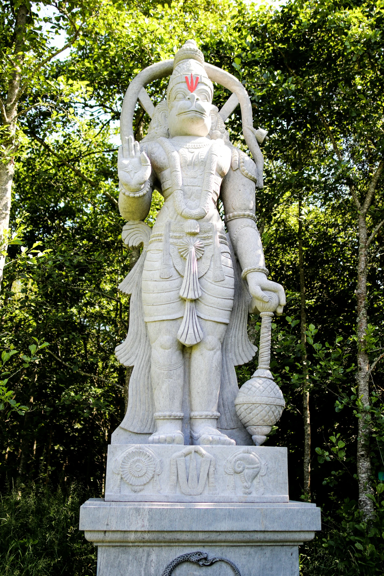 a statue of a god and woman with horns in the woods