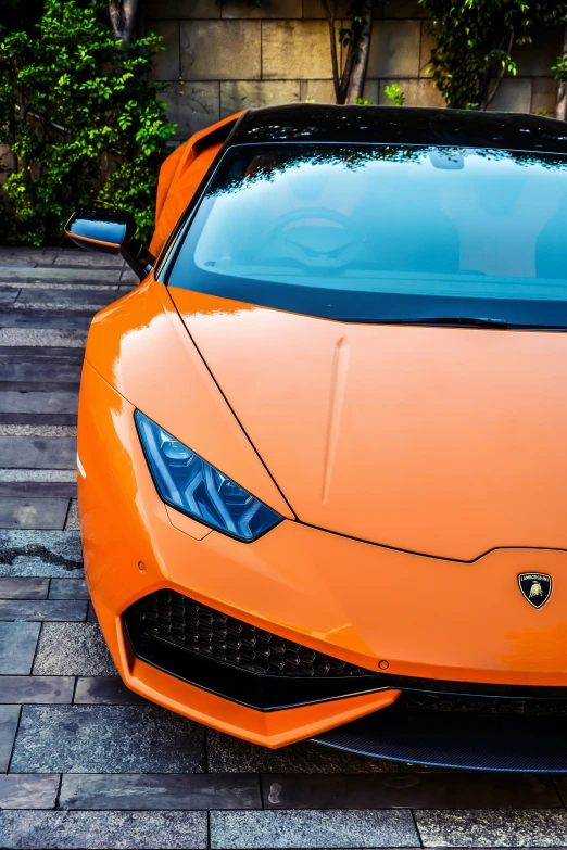 an orange sports car sitting on a road