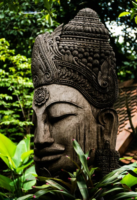 the statue sits in front of lush foliage