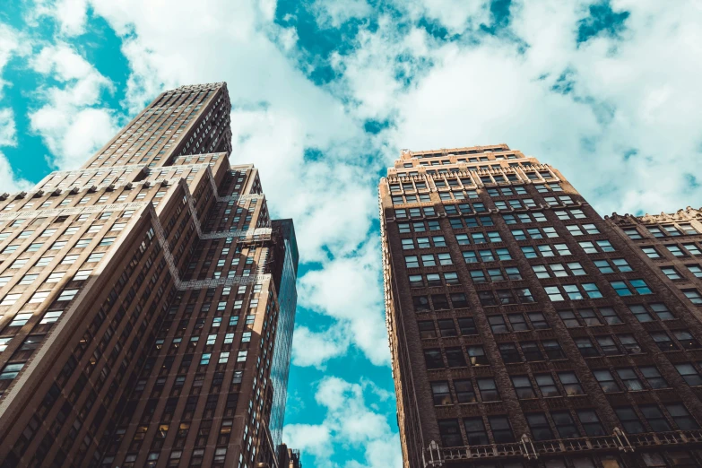 an image of two tall buildings taken from below