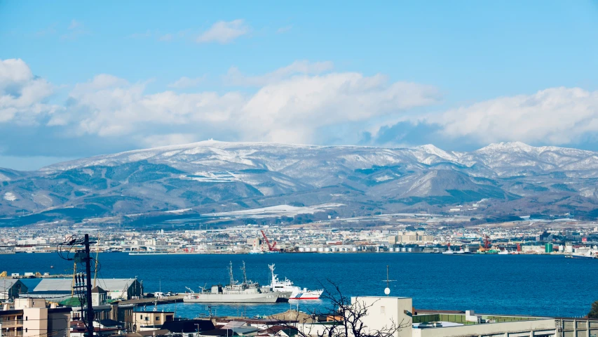 a boat docked near the shore in front of a mountain range