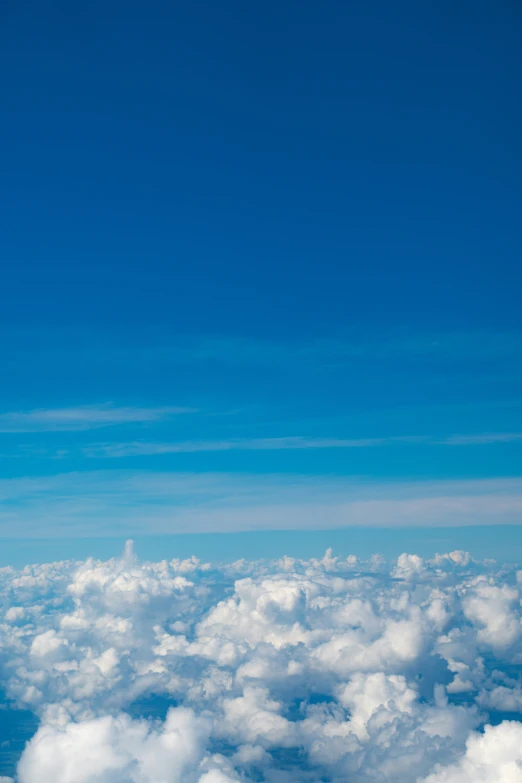 a large jetliner flying over some clouds