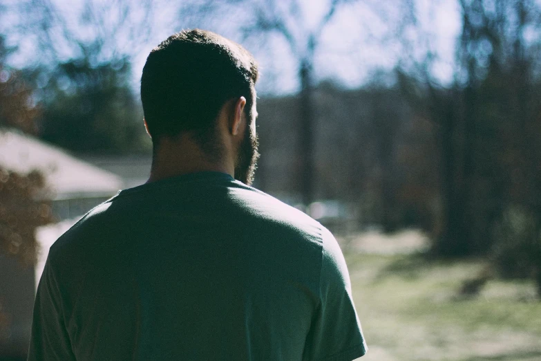 a man sitting in the grass near his yard