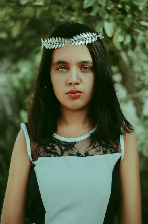 a girl wearing a tiara and a dress looks at the camera