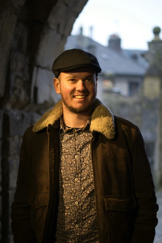 a man with a hat on standing in front of a building