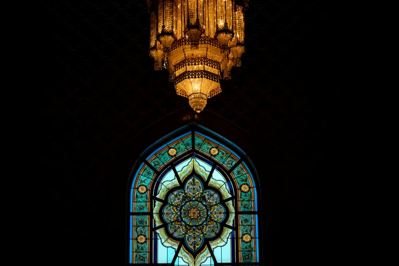 a stain glass window with chandelier hangs over it