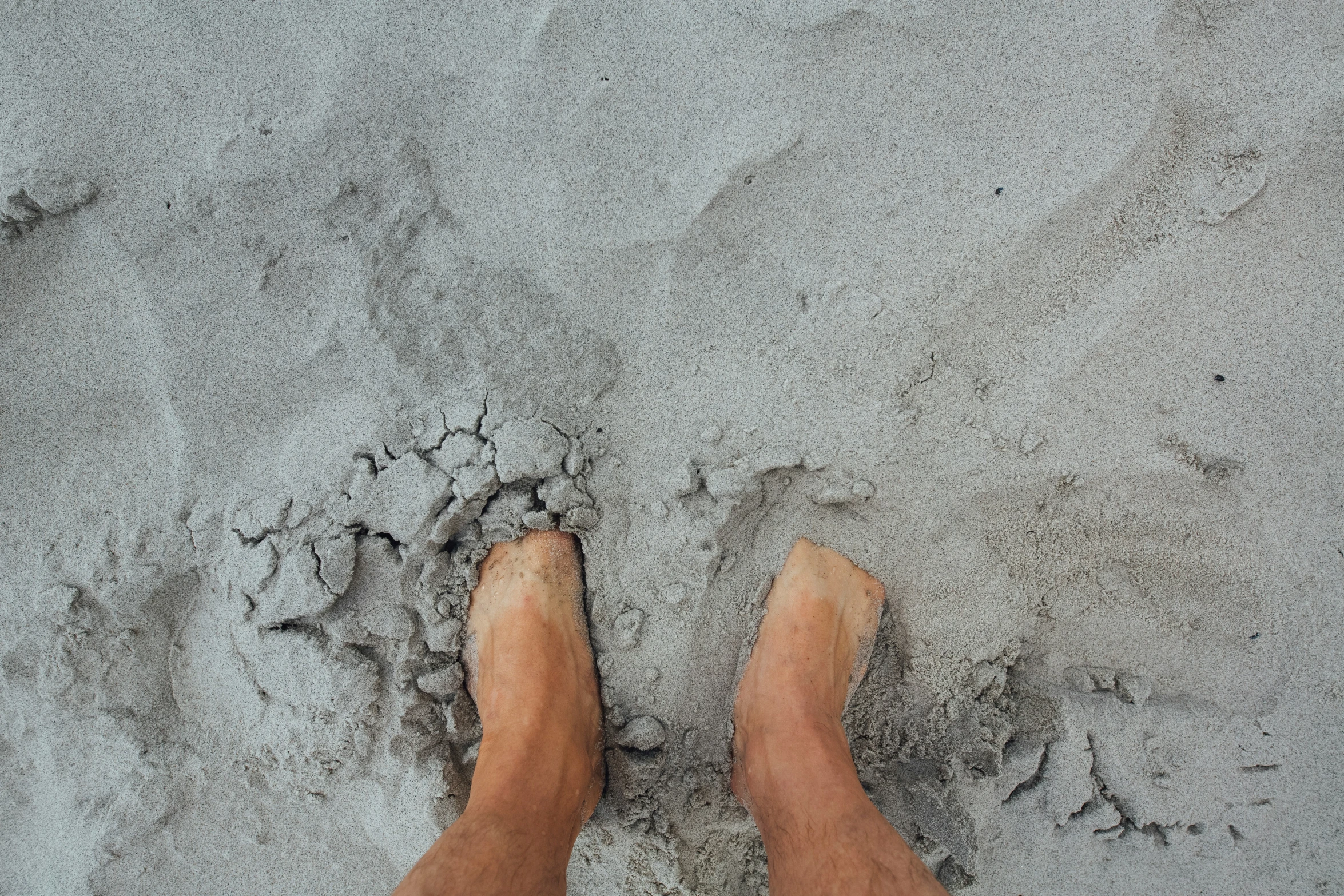 a beach view with a pair of feet in the sand