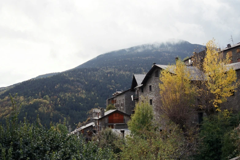 a row of wooden buildings sitting on top of a lush green hillside