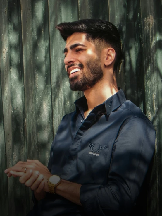 man with beard in front of wood wall and sunlight