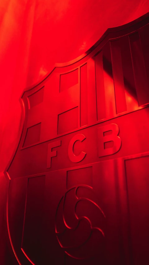 red illuminated emblem on red wall at night