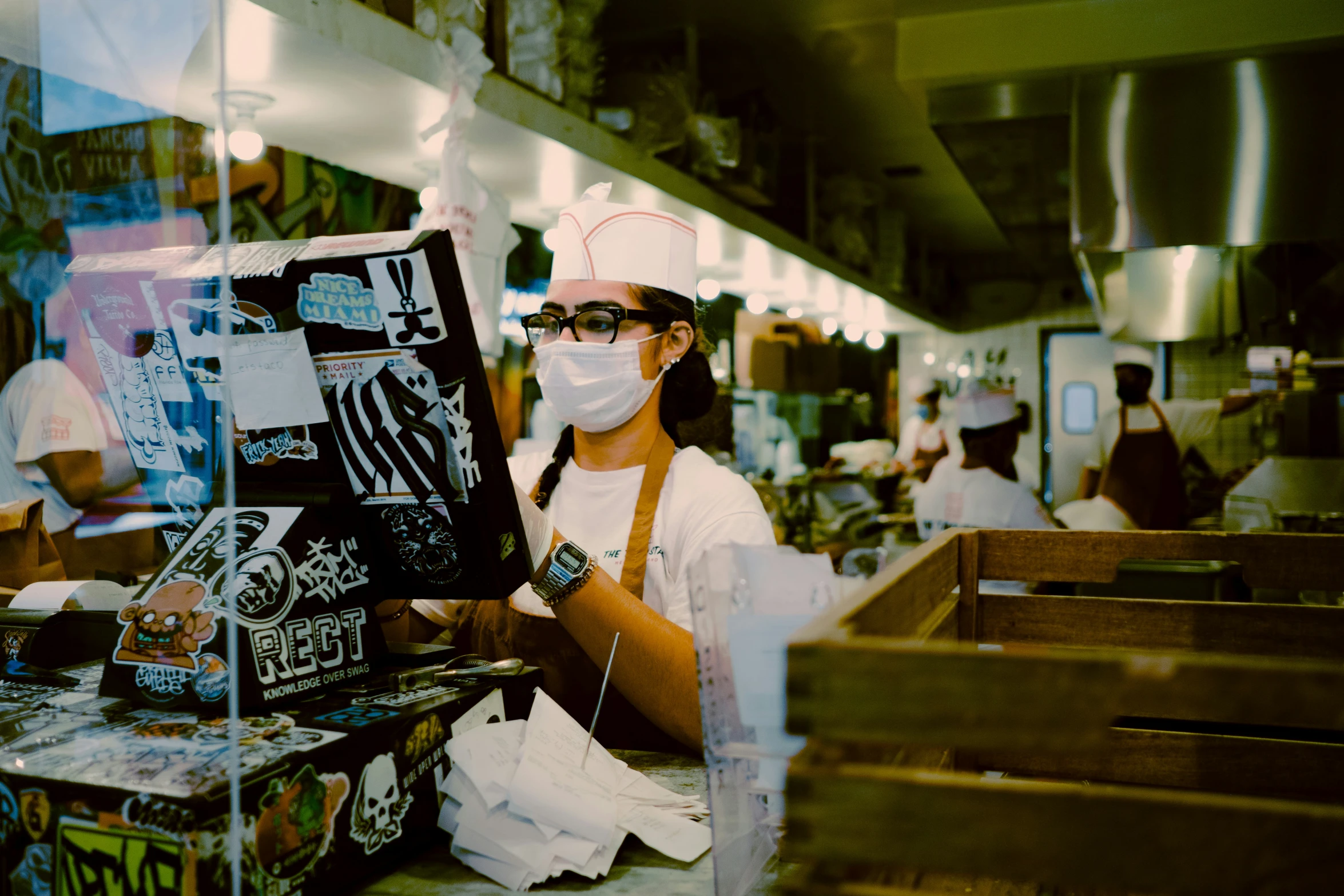 a person wearing a mask standing in a restaurant