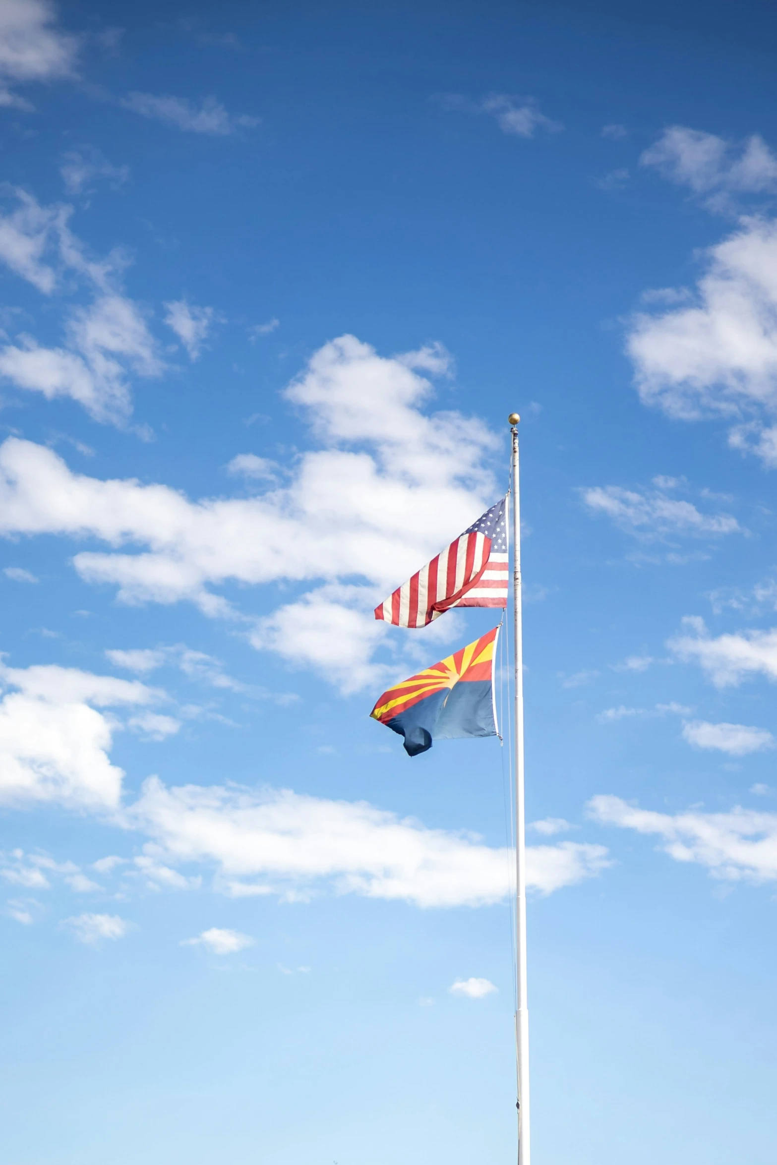 an american and spanish flags waving together in the wind