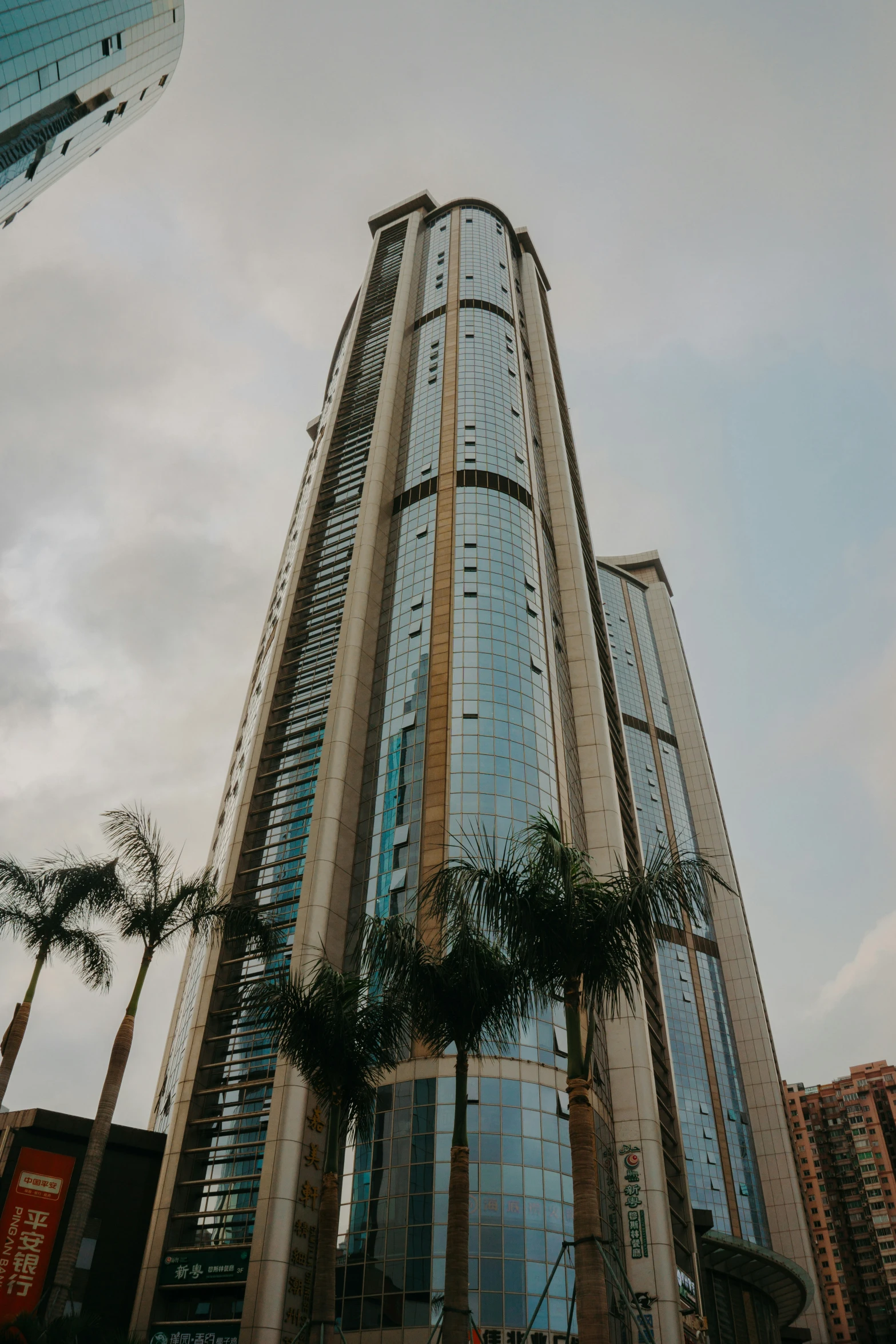 the front of a very tall building with palm trees