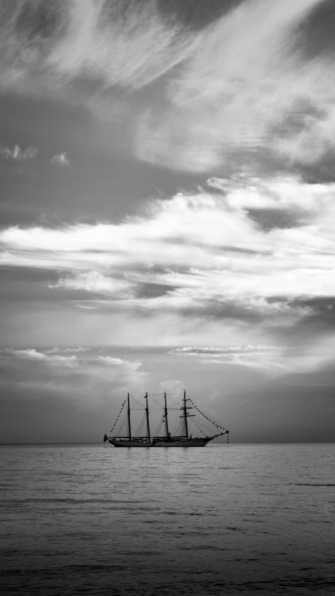 a boat with sails floating across the water