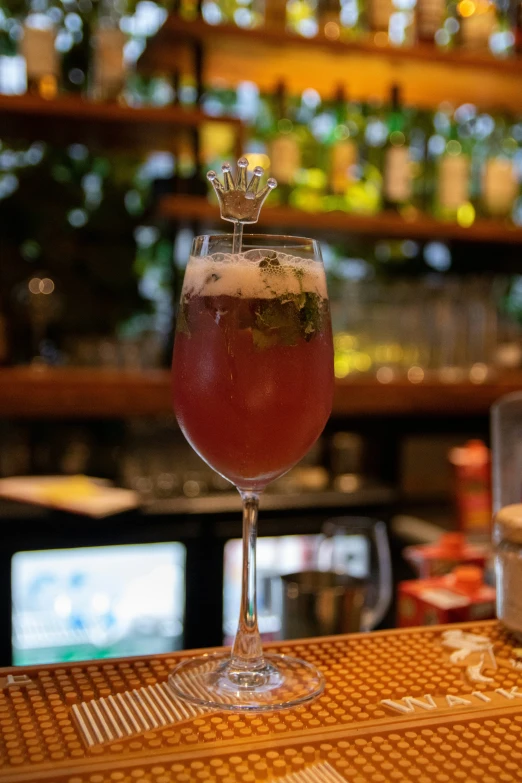 a glass filled with a drink sitting on top of a bar