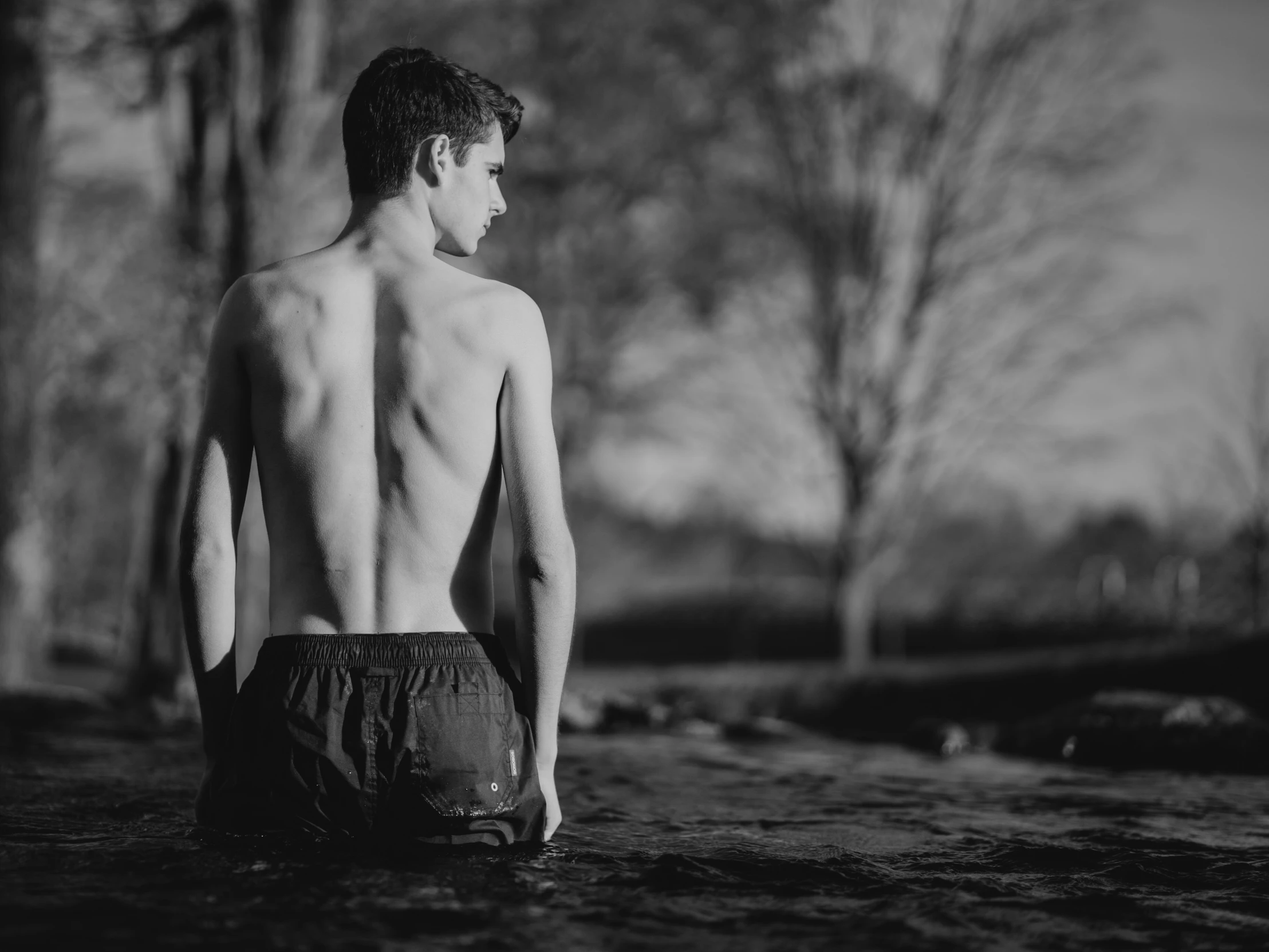 a shirtless man with s is standing in the middle of the park