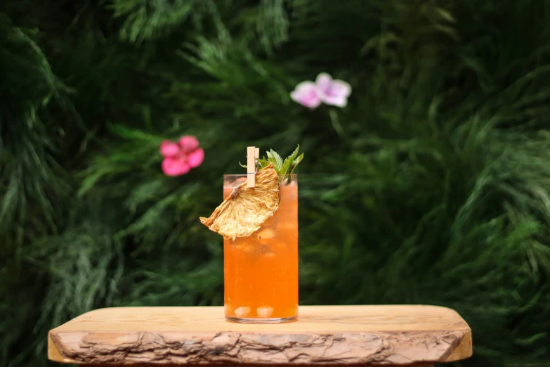 a cocktail is sitting on a table with a leaf on it