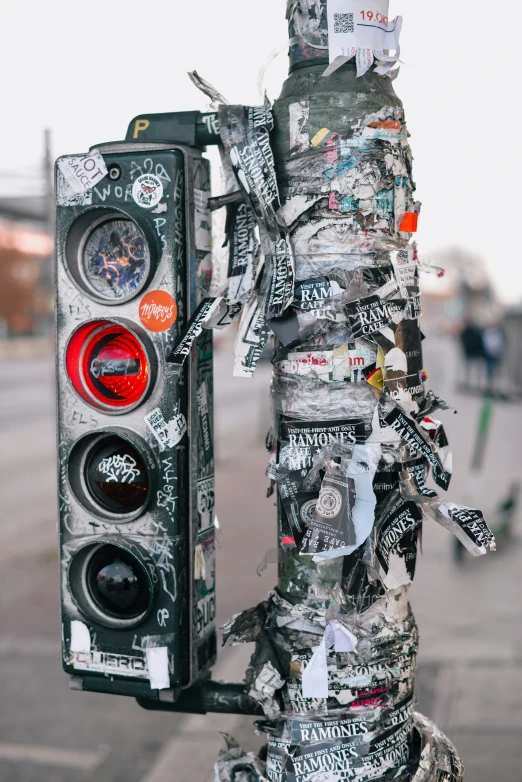 the street pole has several stickers all over it