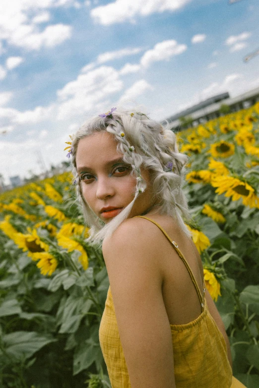 woman with blonde hair standing in a sunflower field