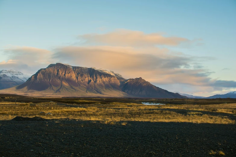 a large mountain in the distance with some very tall mountains behind it