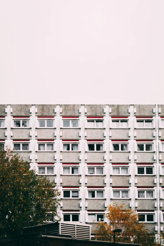 the facade of an apartment building with trees in the foreground