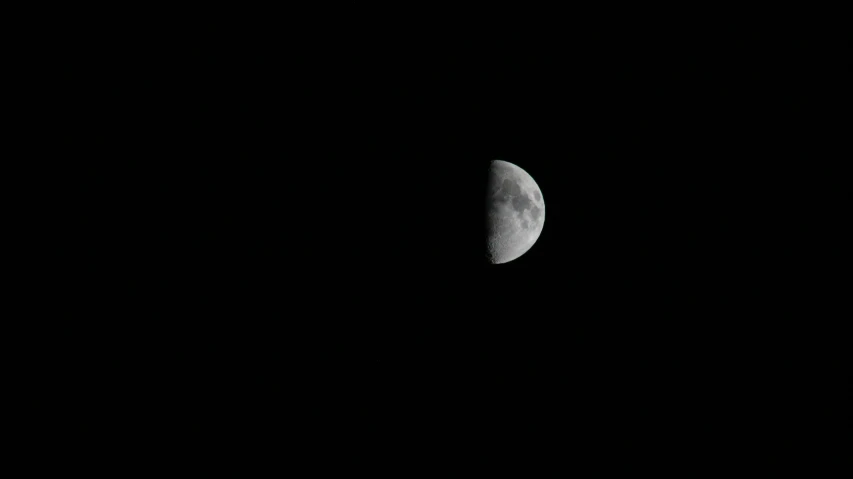 a half moon with black skies in the background