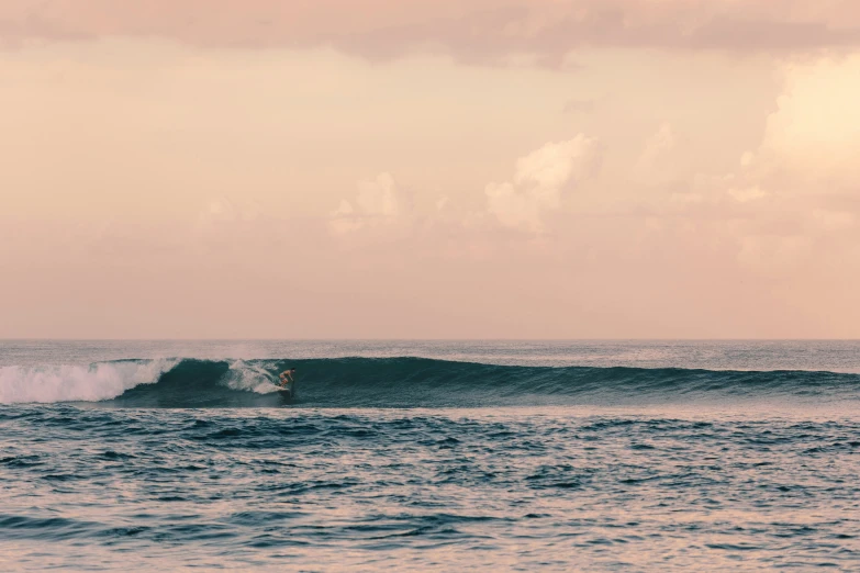 person on surfboard riding on top of wave