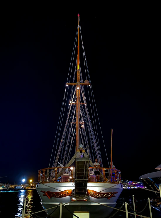 a white sailboat is docked at the dock at night