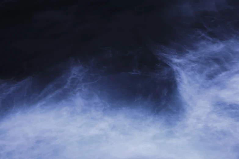 a jet flying through the sky under clouds